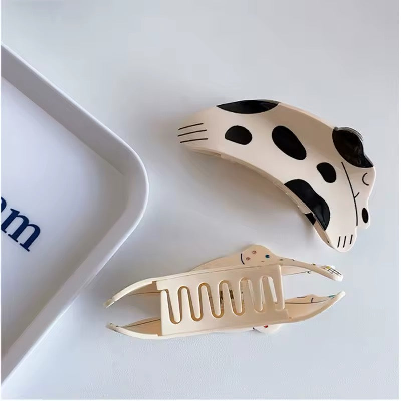 The hair claw clip holding back a section of straight hair, showcasing its suitability for different hair textures