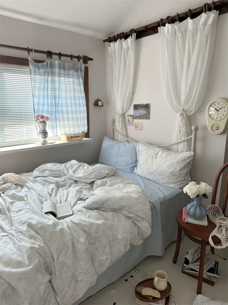Cozy bedroom with a bed, side table, and window with curtains.