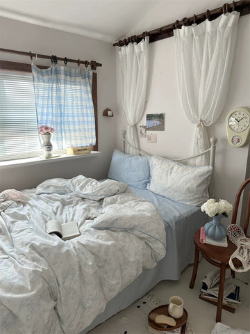 Cozy bedroom with a bed, side table, and window with curtains.