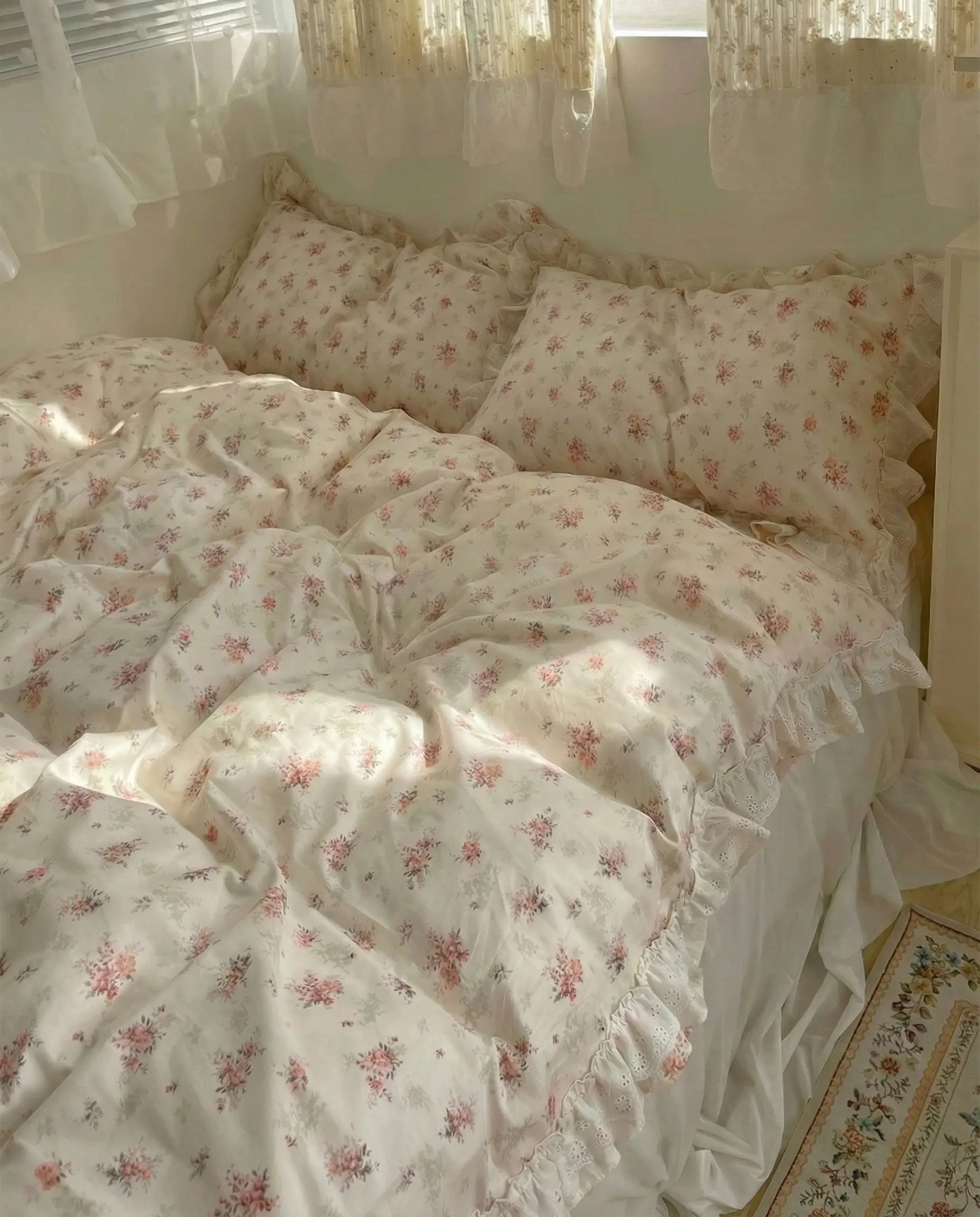 Floral patterned bedding set on a bed with light curtains in the background