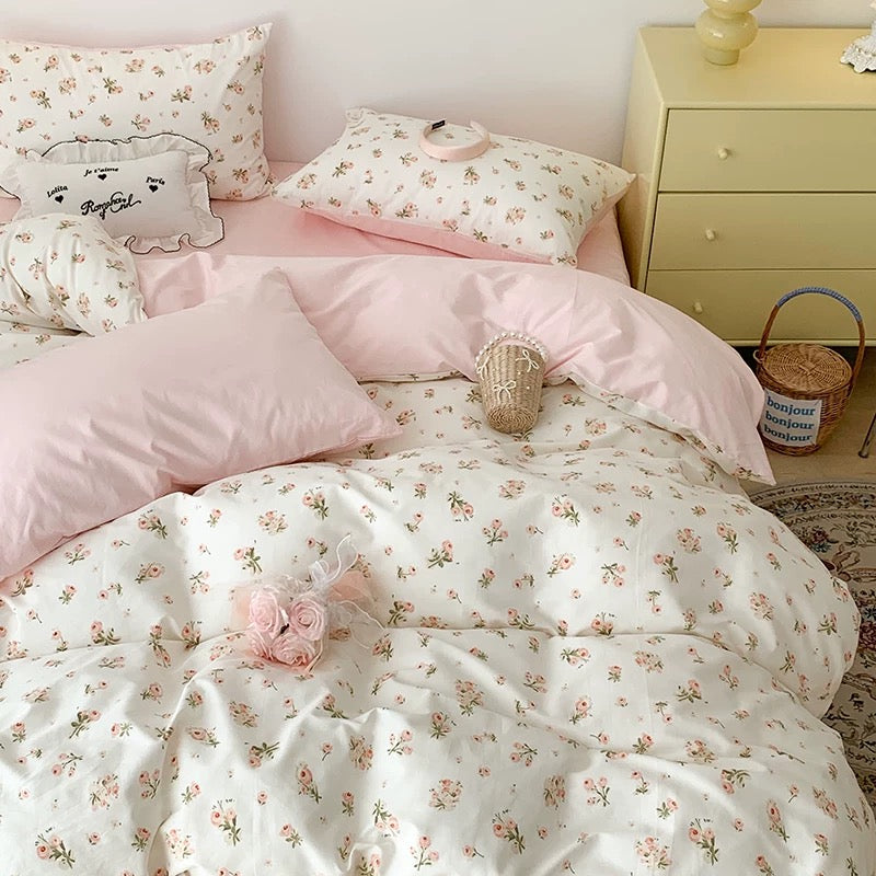 Floral bedding set on a bed with a nightstand in the background