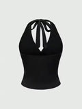 Black halter top with bow detail on a light gray background