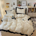 White comforter with black polka dots and trim on a bed in a bedroom setting.