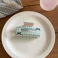 Gingham triangle clip styled with soft girl accessories and warm lighting for a gentle aesthetic