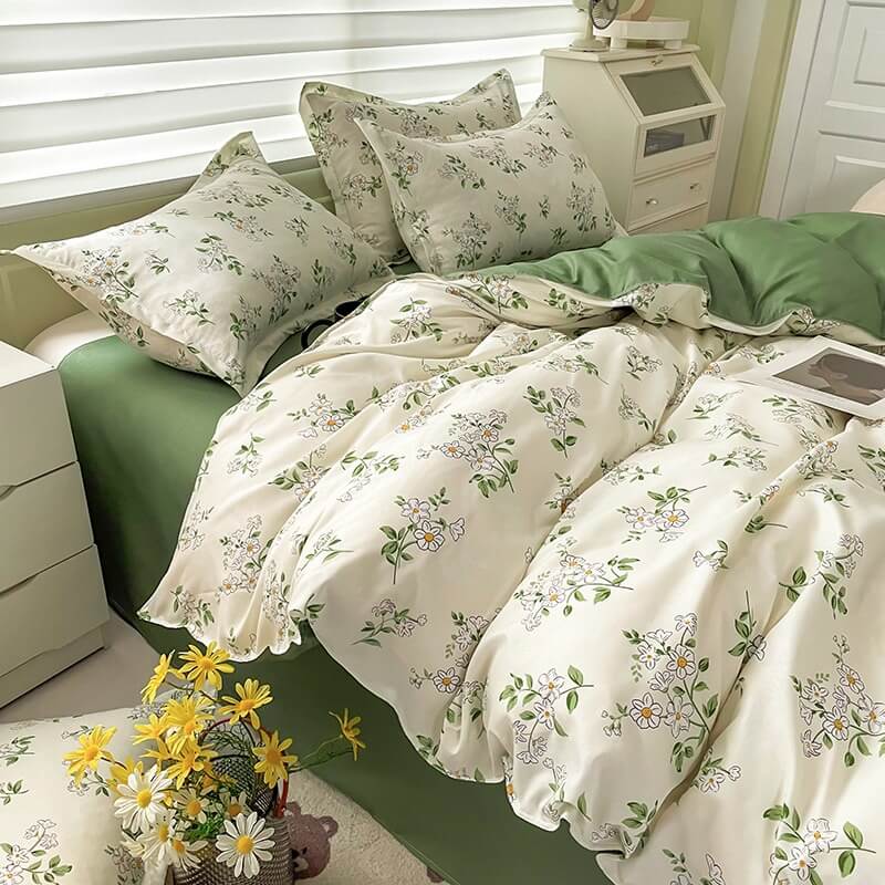 Floral bedding set on a bed in a bedroom with a nightstand and window blinds.