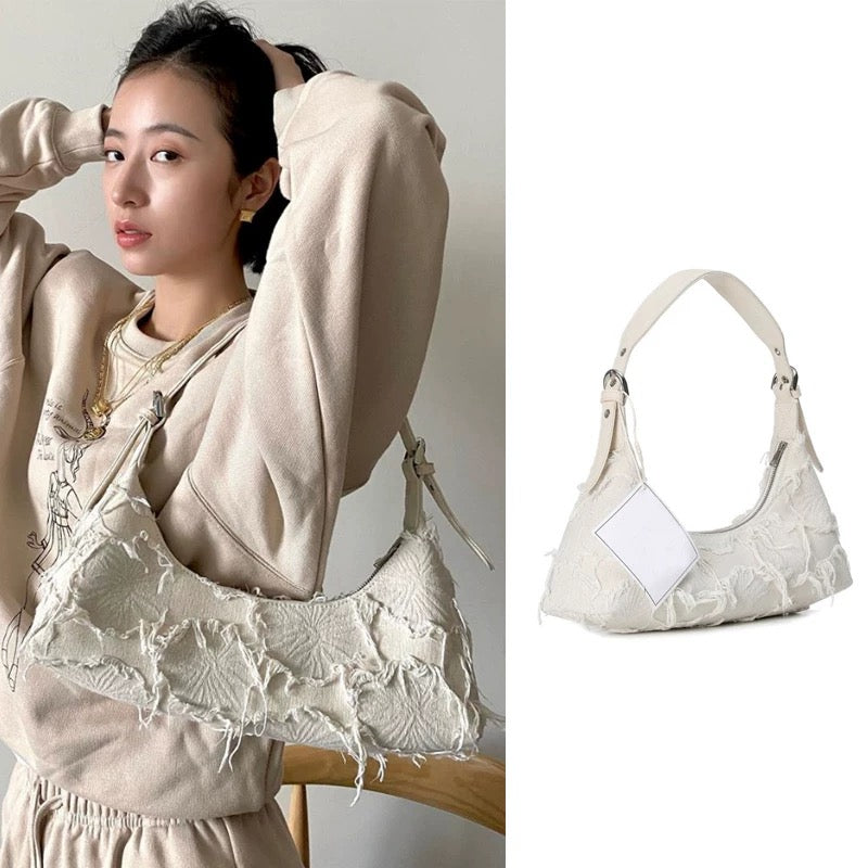 Soft girl baguette shoulder bag with tassel details and canvas fabric in neutral tones for aesthetic outfits