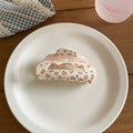 Blue heart-shaped hair claw clip with pink plaid centers, styled for a soft girl or balletcore look