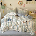 Striped bedding set with cartoon characters on a bed in a room.