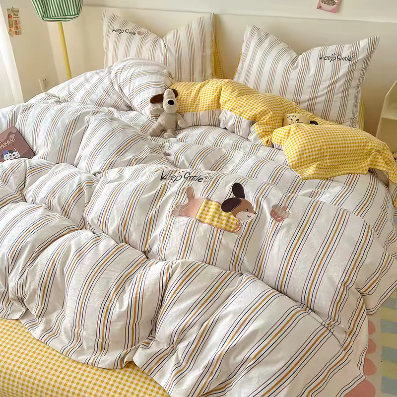 Striped bedding with cartoon dog appliqués and yellow checkered pillows in a bedroom setting.