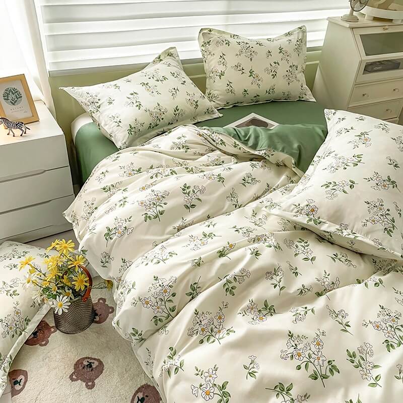 Floral bedding set on a bed in a bedroom with white walls and furniture.