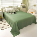 Bed with green bedding in a bedroom setting