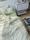 Bed with white bedding and pillows next to a nightstand with decorative items.