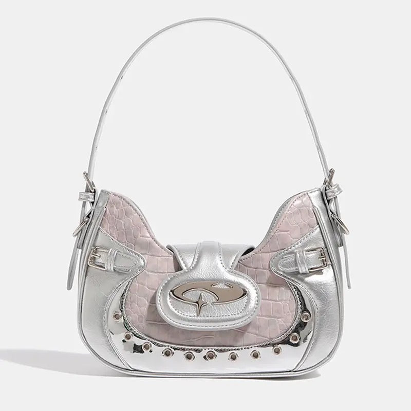 Y2K crescent-shaped shoulder and crossbody bag in silvery pink with crocodile texture, punk-inspired details and metal rivets for edgy 2000s fashion outfits