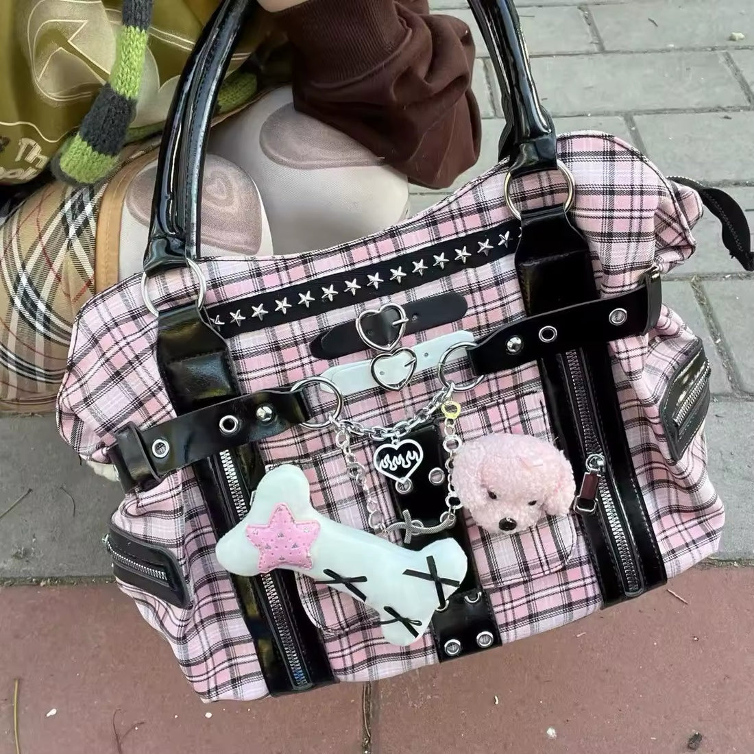 Front view of the Pink Plaid Grunge Shoulder Bag showcasing its bold pattern and rivet details.