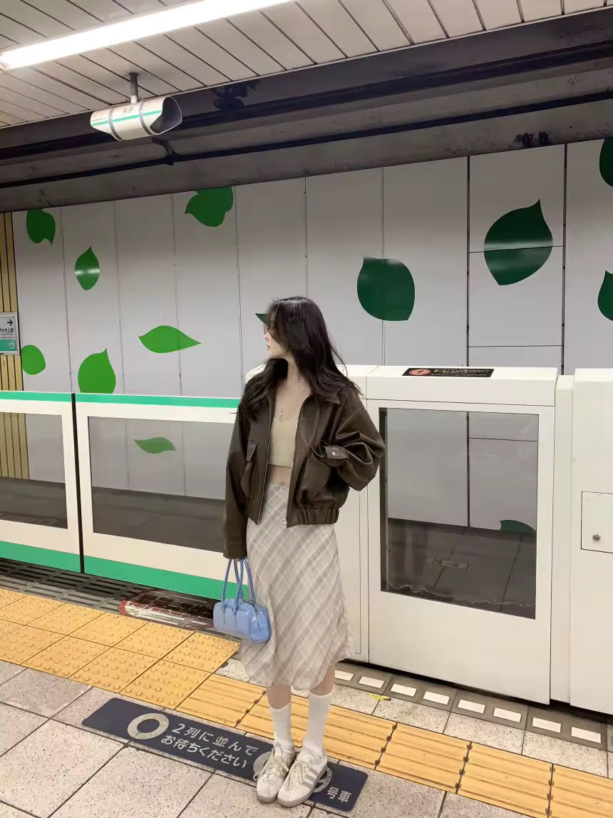 Vintage plaid midi skirt styled with brown jacket in subway
