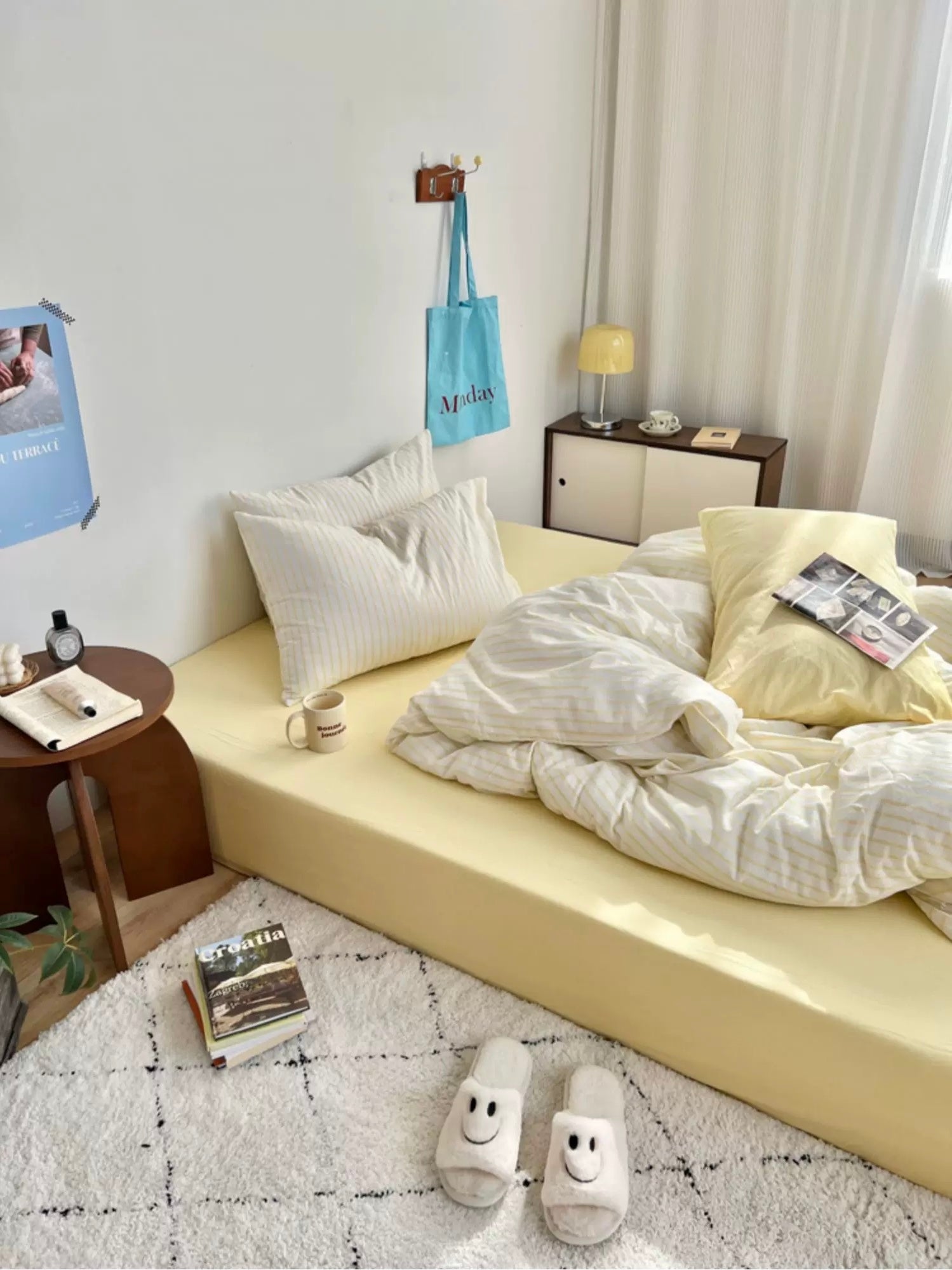 Modern bedroom with a bed, side table, and decor items.