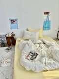 Bedroom with a yellow bedspread, white pillows, and a white comforter.